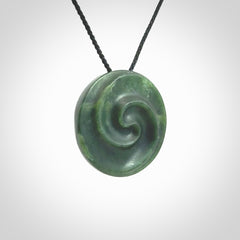 This pendant is a medium sized double koru necklace carved from a New Zealand Jade with Mother of Pearl inlay. Kyohei Noguchi carved this piece for us so the workmanship is outstanding. Handmade in New Zealand, a beautiful piece of jade jewellery.
