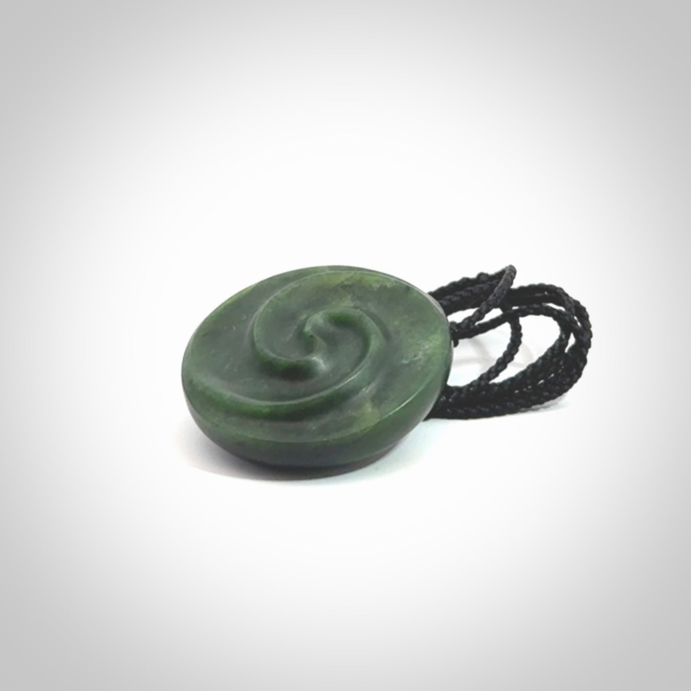 This pendant is a medium sized double koru necklace carved from a New Zealand Jade with Mother of Pearl inlay. Kyohei Noguchi carved this piece for us so the workmanship is outstanding. Handmade in New Zealand, a beautiful piece of jade jewellery.