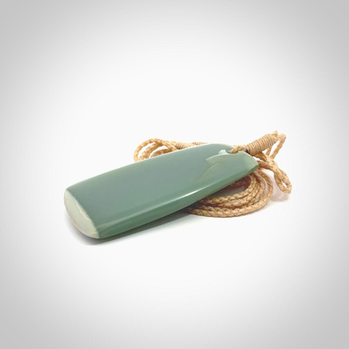 This is a lovely New Zealand Inanga Jade, pounamu Toki drop pendant. Hand carved for us by Kyohei Noguchi. It is bound with an adjustable beige coloured cord which is length adjustable. Free worldwide shipping.