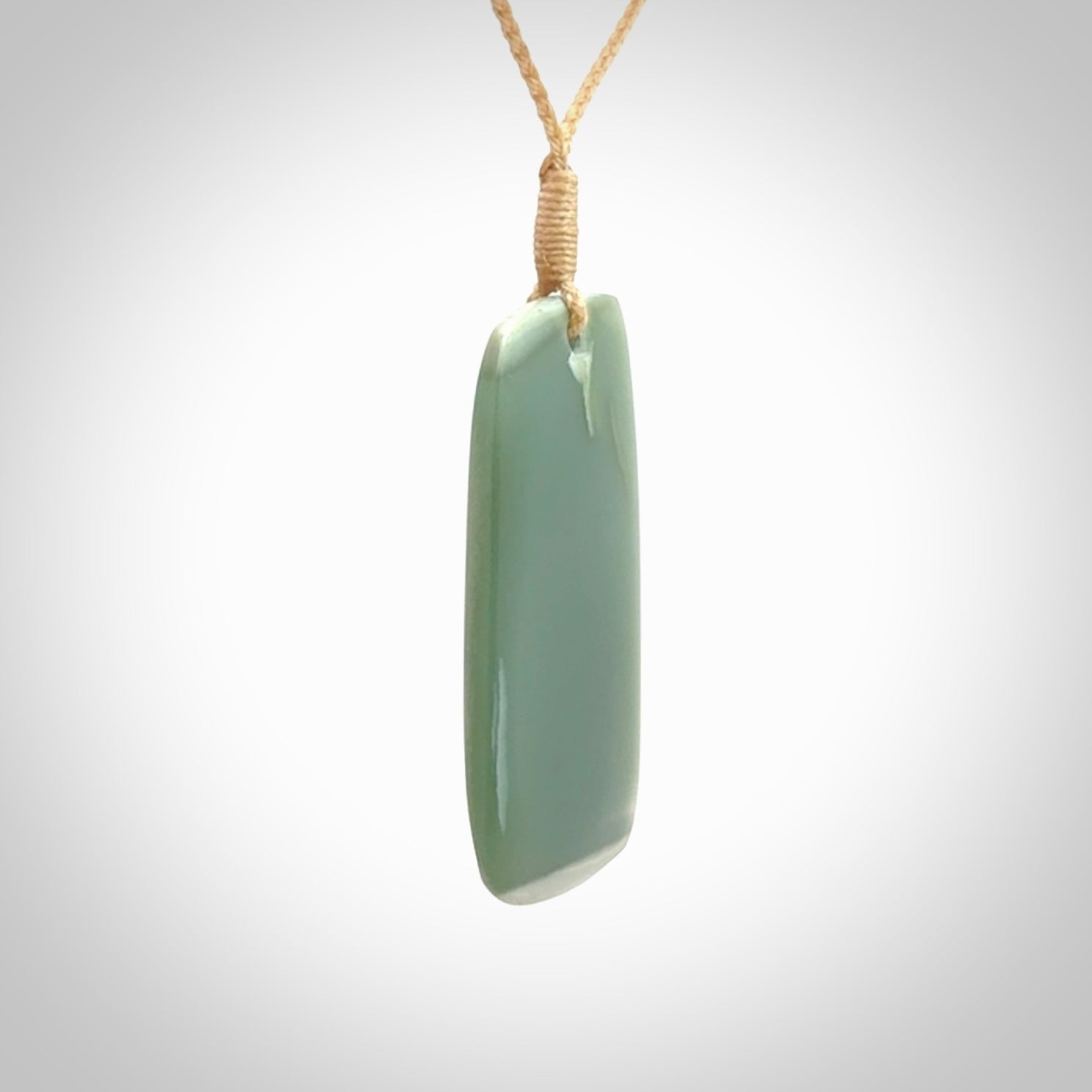 This is a lovely New Zealand Inanga Jade, pounamu Toki drop pendant. Hand carved for us by Kyohei Noguchi. It is bound with an adjustable beige coloured cord which is length adjustable. Free worldwide shipping.