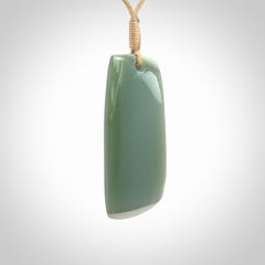 This is a lovely New Zealand Inanga Jade, pounamu Toki drop pendant. Hand carved for us by Kyohei Noguchi. It is bound with an adjustable beige coloured cord which is length adjustable. Free worldwide shipping.
