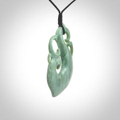 This picture shows a contemporary manaia with hook pendant carved for us by Kyohei Noguchi. It is a light green colour in traditional manaia design. We have plaited a cord in black and made it length adjustable. This is a very beautiful piece of art to wear.