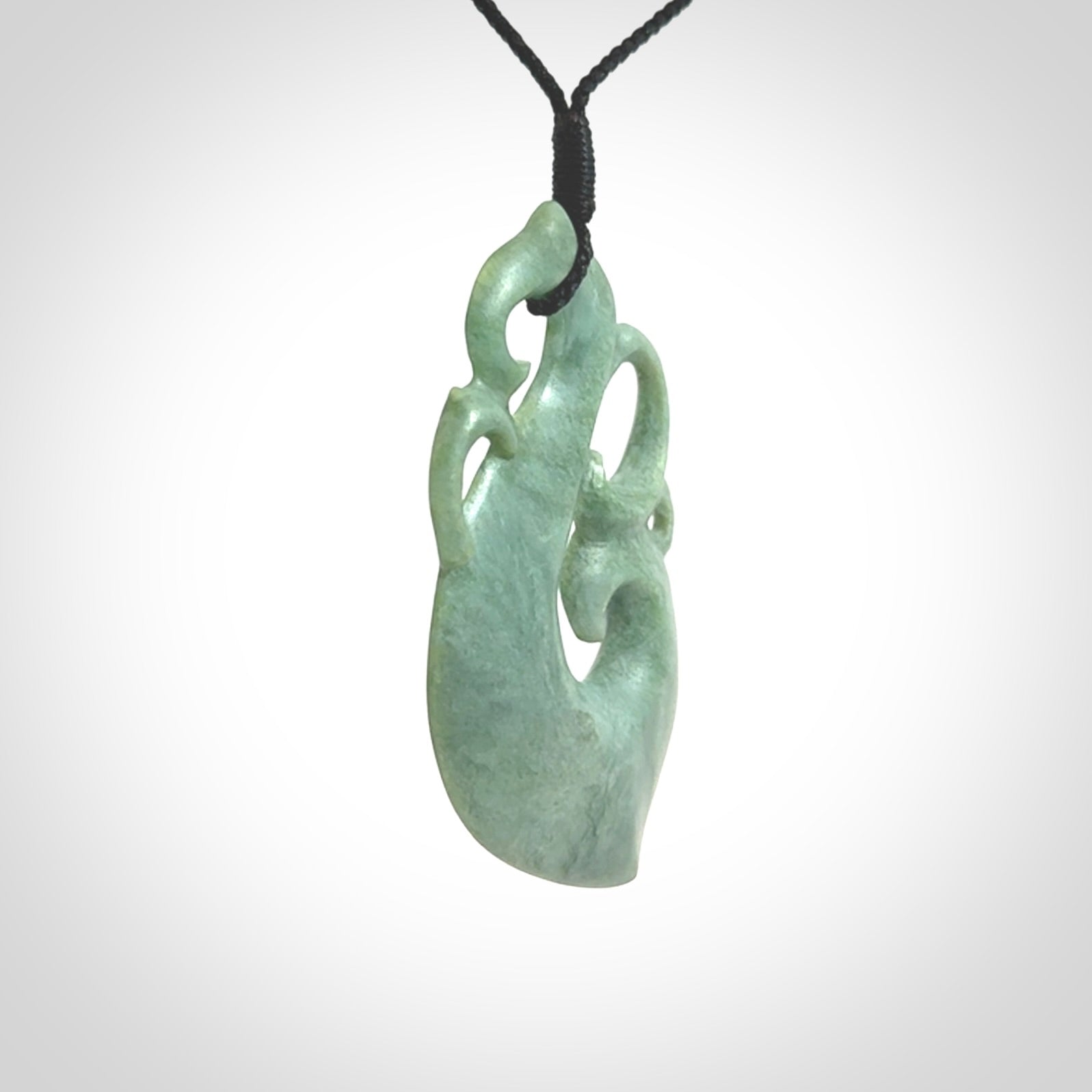 This picture shows a contemporary manaia with hook pendant carved for us by Kyohei Noguchi. It is a light green colour in traditional manaia design. We have plaited a cord in black and made it length adjustable. This is a very beautiful piece of art to wear.