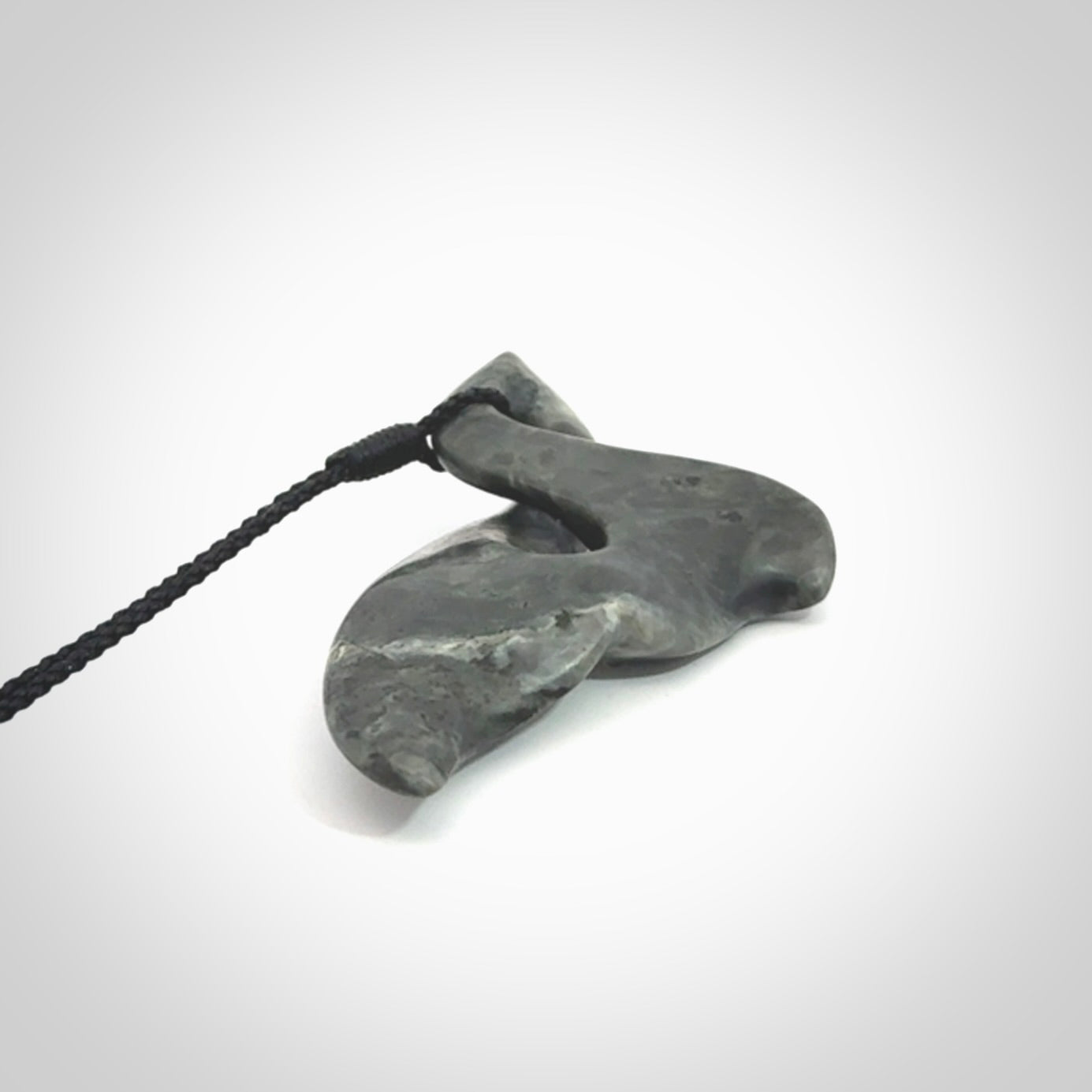 This whale tail twist pendant, is carved from a very striking New Zealand Nelson jade.