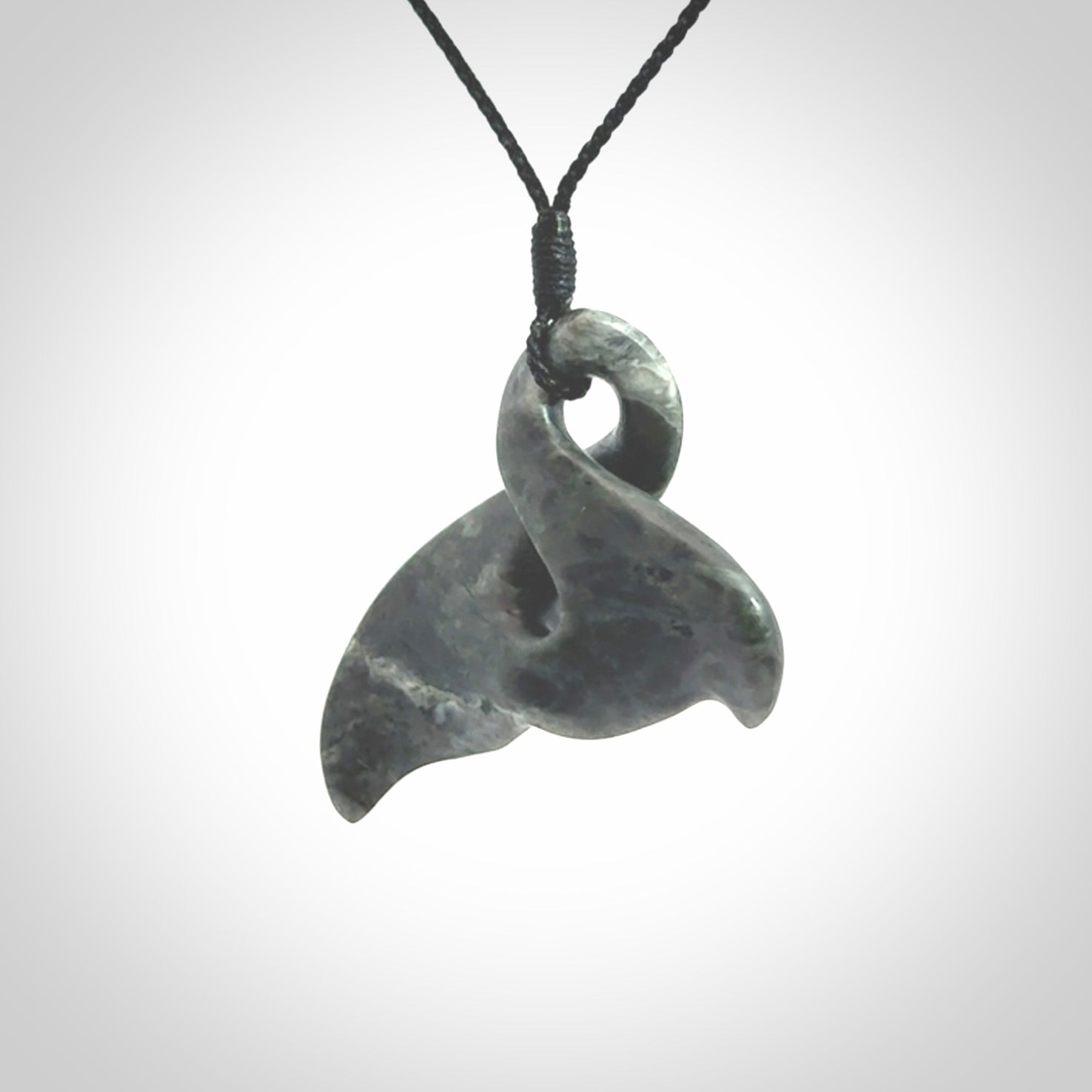 This whale tail twist pendant, is carved from a very striking New Zealand Nelson jade.