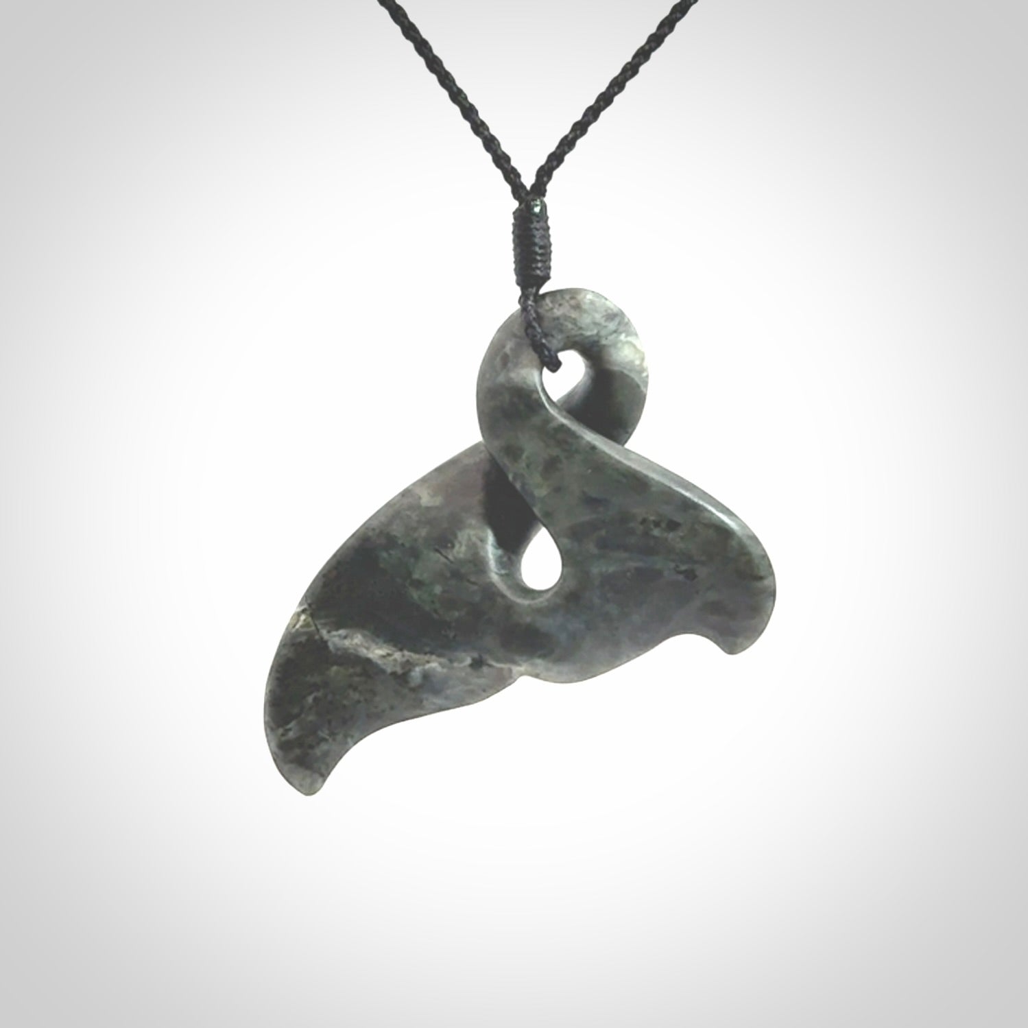 This whale tail twist pendant, is carved from a very striking New Zealand Nelson jade.