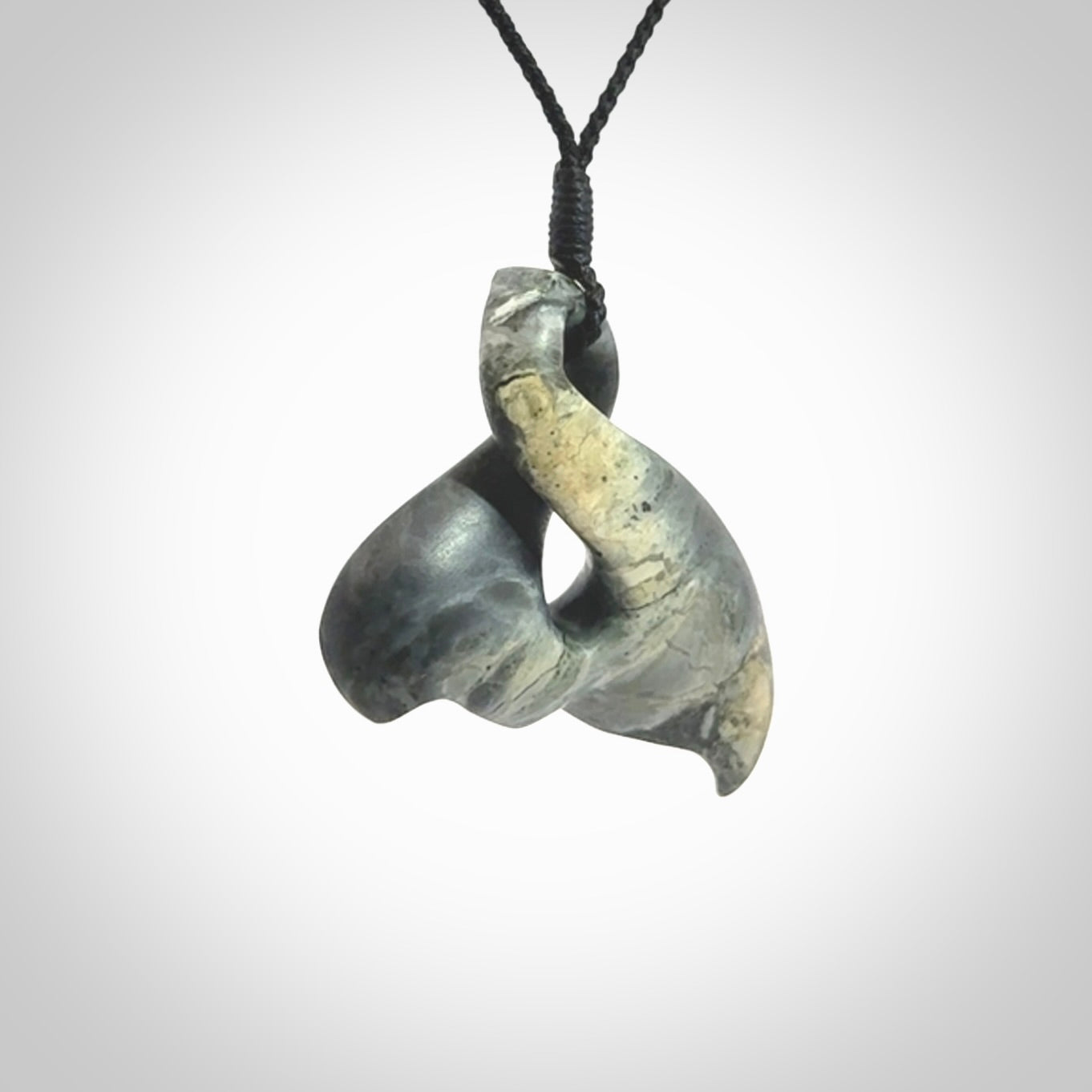 This whale tail twist pendant, is carved from a very striking New Zealand Nelson jade.