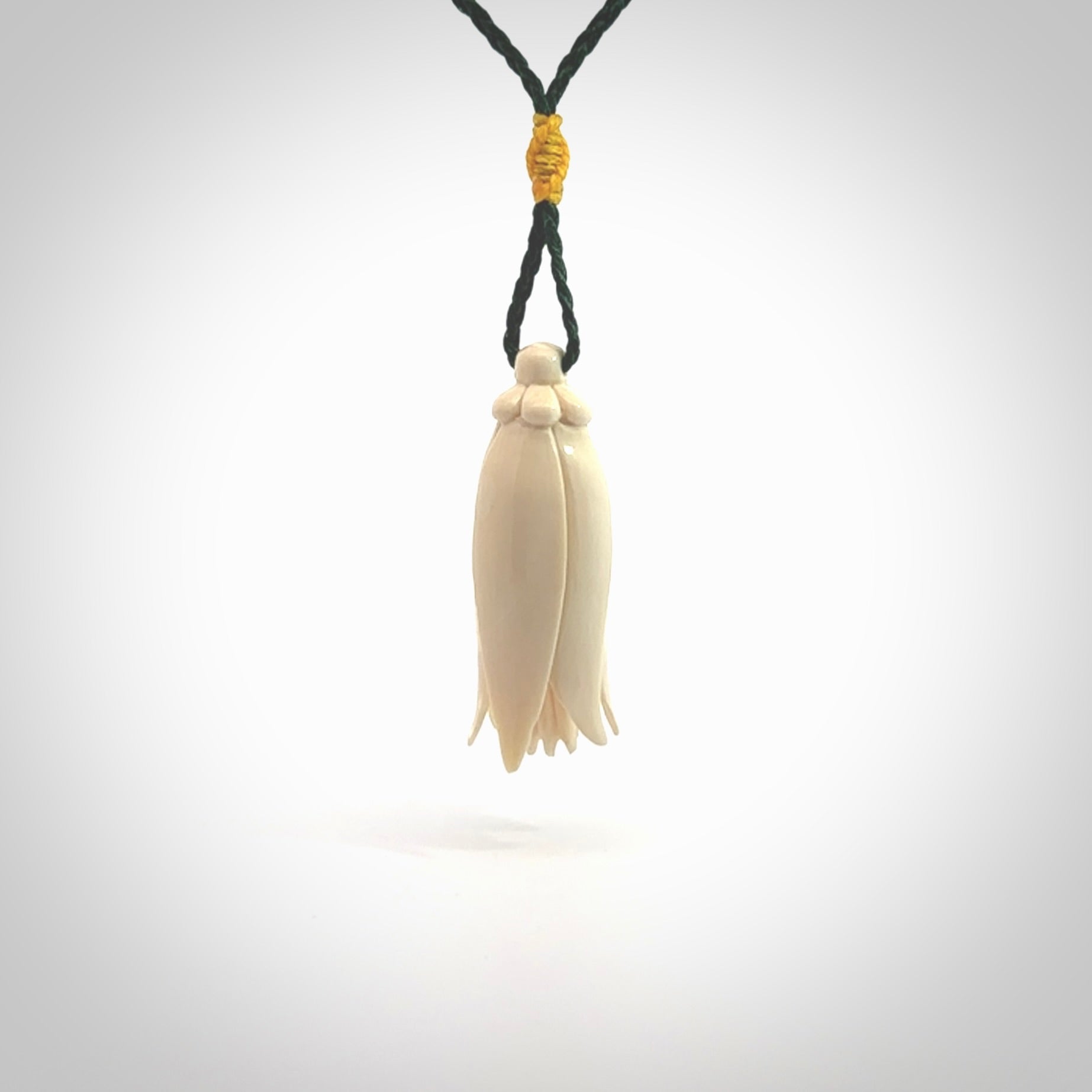 Hand carved Kowhai flower. These are made from Woolly Mammoth tusk and are a soft golden brown colour. They are provided with a hand plaited, adjustable cord. Shipping is free worldwide.