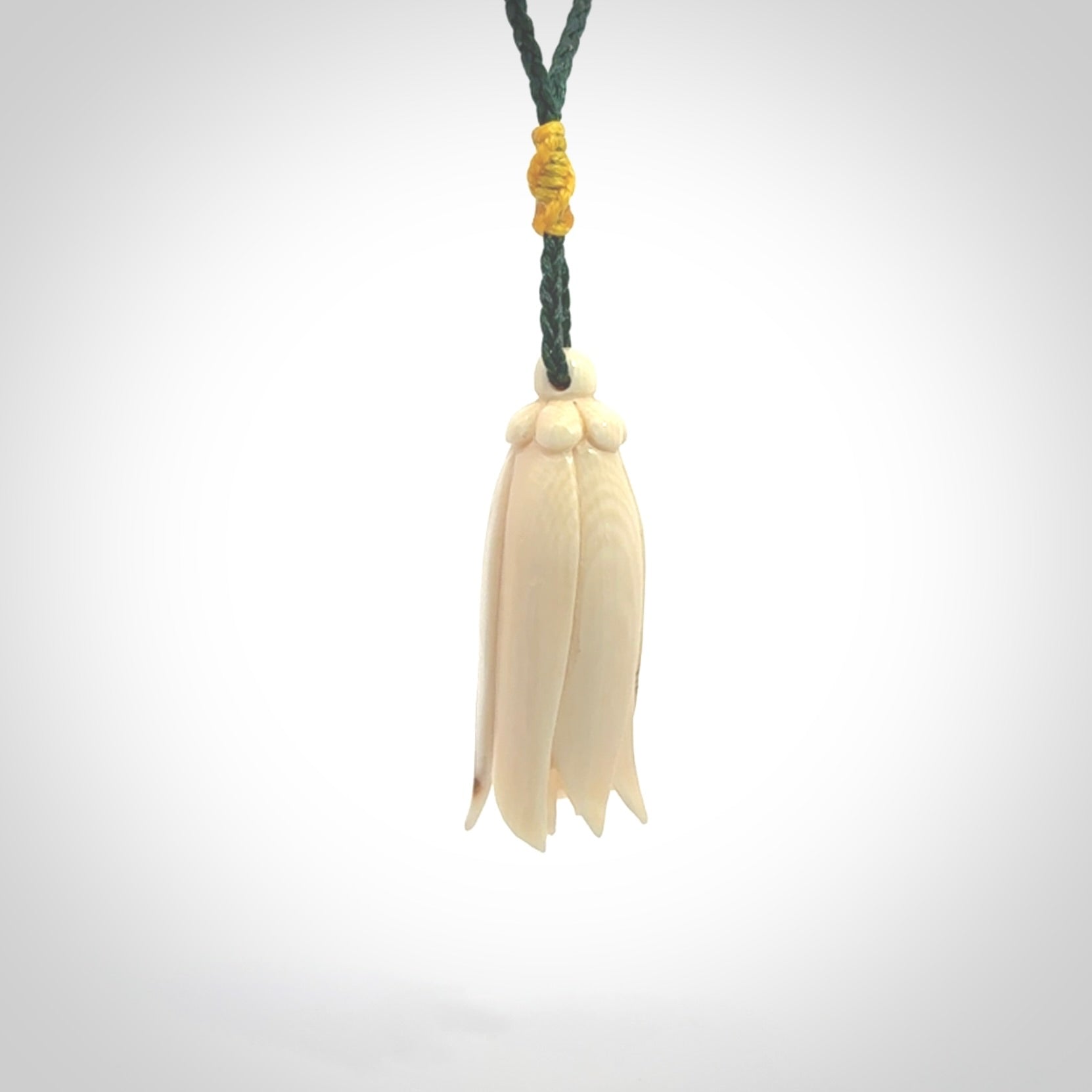 Hand carved Kowhai flower. These are made from Woolly Mammoth tusk and are a soft golden brown colour. They are provided with a hand plaited, adjustable cord. Shipping is free worldwide.