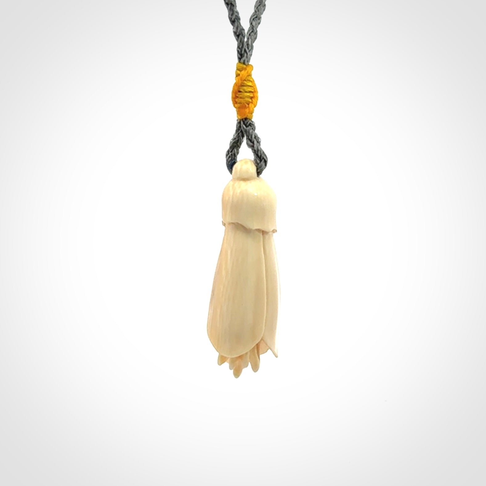 Hand carved Kowhai flower. These are made from Woolly Mammoth tusk and are a soft golden colour. They are provided with a hand plaited, adjustable cord. Shipping is free worldwide.