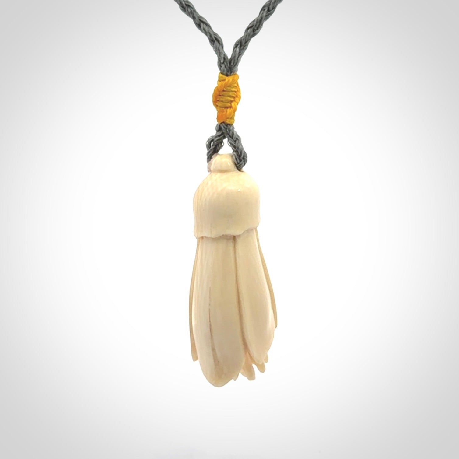Hand carved Kowhai flower. These are made from Woolly Mammoth tusk and are a soft golden colour. They are provided with a hand plaited, adjustable cord. Shipping is free worldwide.