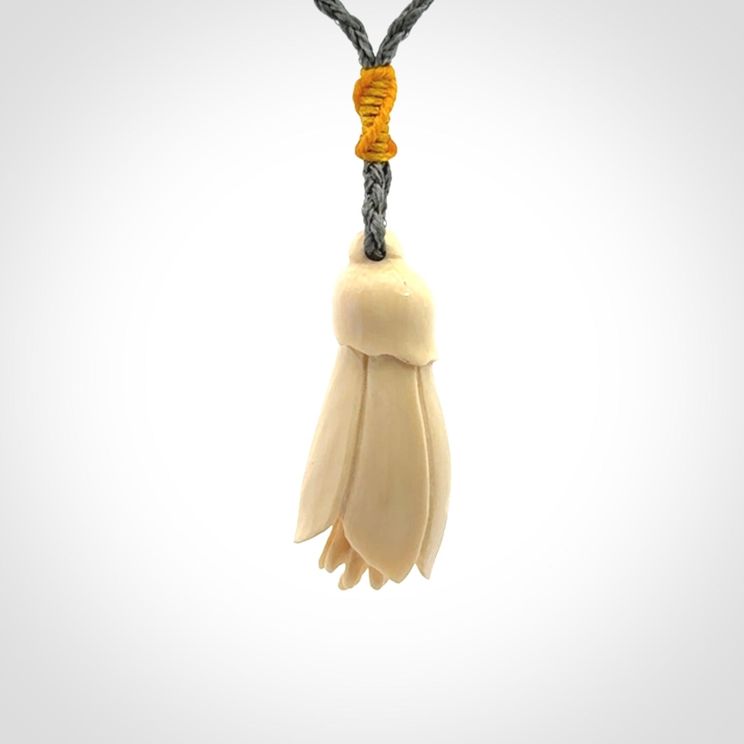 Hand carved Kowhai flower. These are made from Woolly Mammoth tusk and are a soft golden colour. They are provided with a hand plaited, adjustable cord. Shipping is free worldwide.