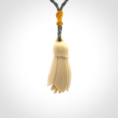 Hand carved Kowhai flower. These are made from Woolly Mammoth tusk and are a soft golden colour. They are provided with a hand plaited, adjustable cord. Shipping is free worldwide.