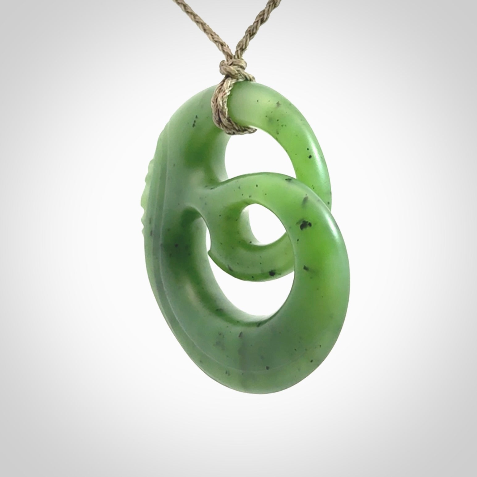 A hand carved complex face pendant from Siberian Jade. The cord is 4-plait khaki and is adjustable.
