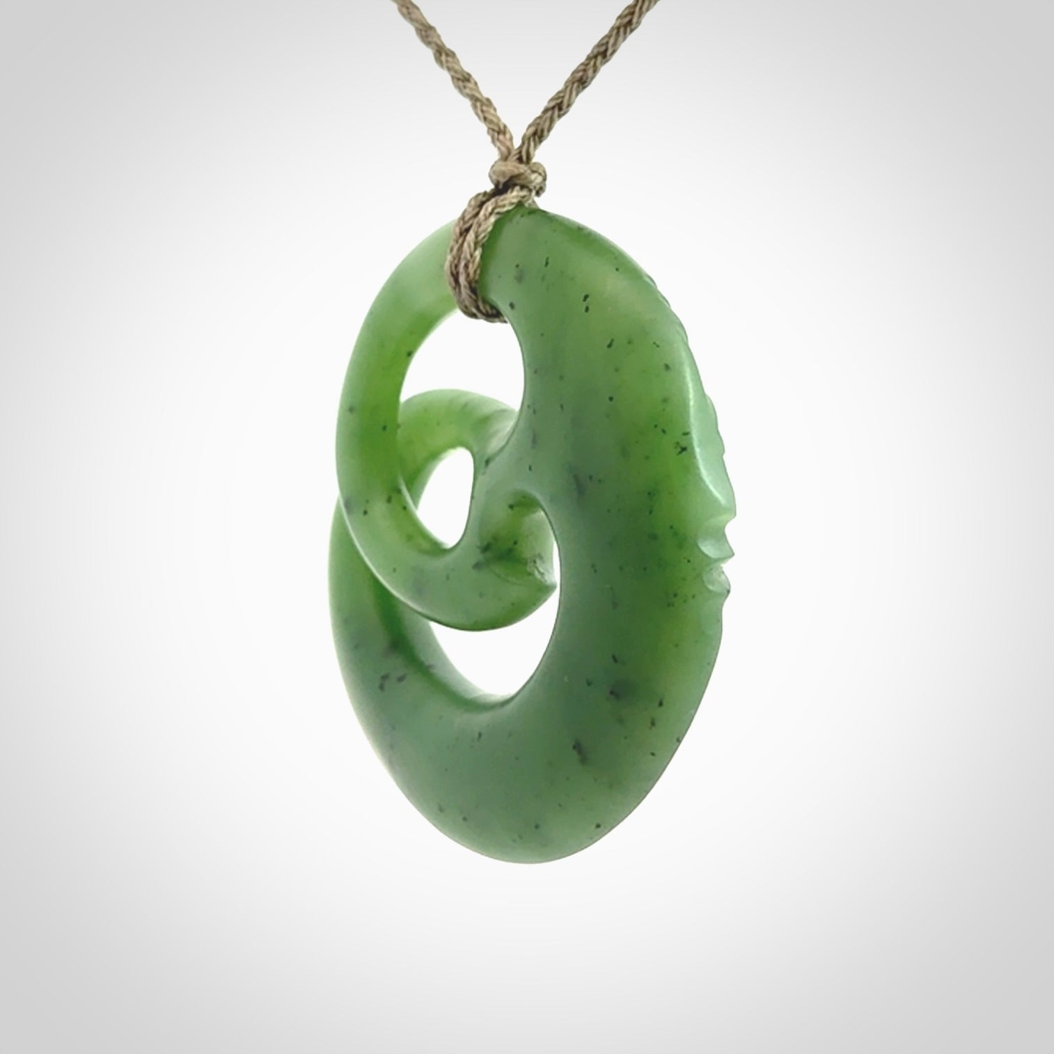 A hand carved complex face pendant from Siberian Jade. The cord is 4-plait khaki and is adjustable.