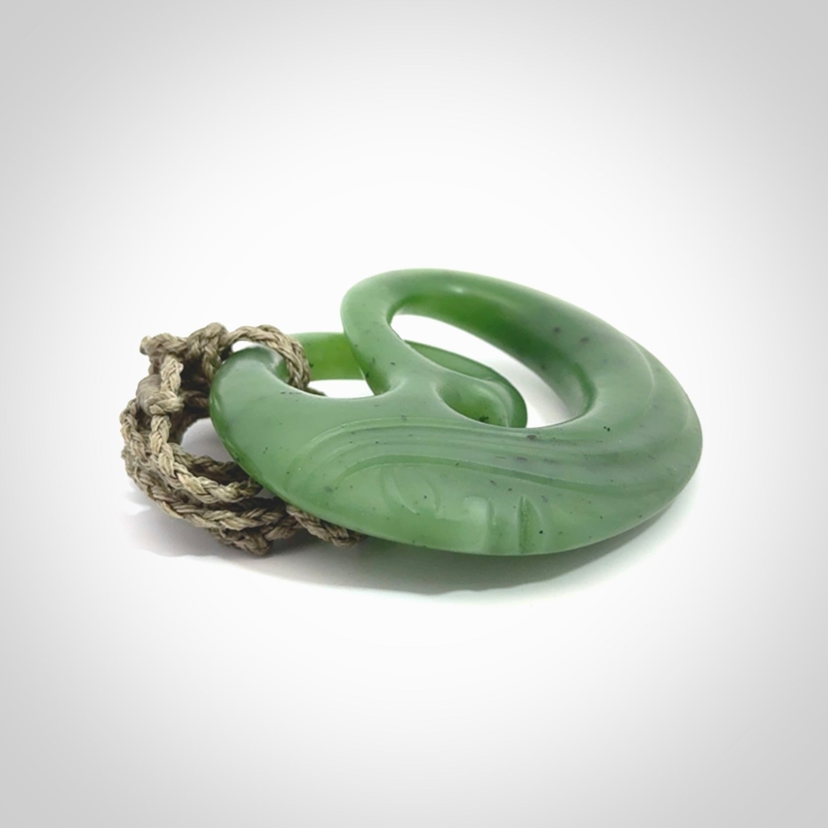 A hand carved complex face pendant from Siberian Jade. The cord is 4-plait khaki and is adjustable.