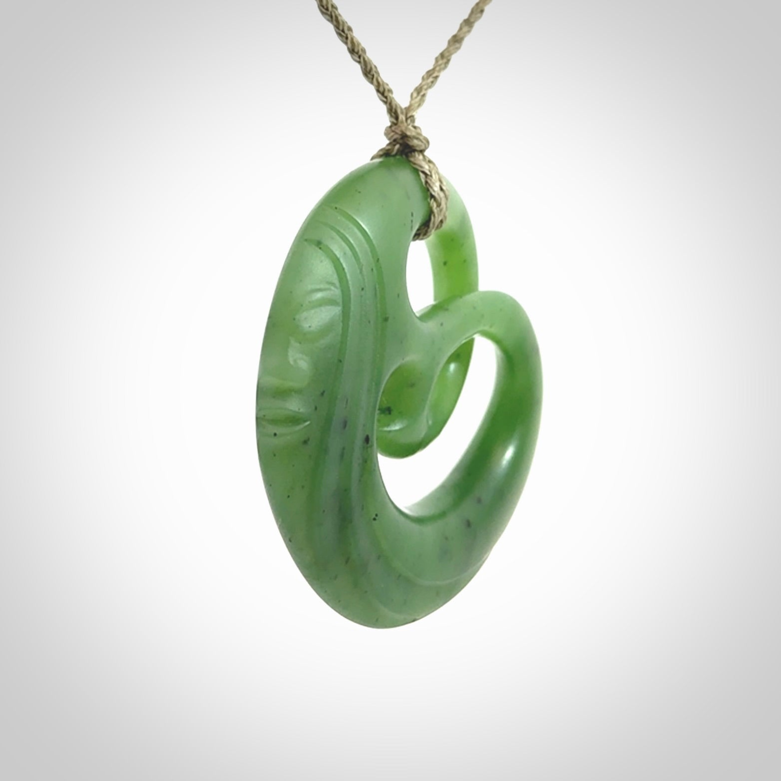A hand carved complex face pendant from Siberian Jade. The cord is 4-plait khaki and is adjustable.