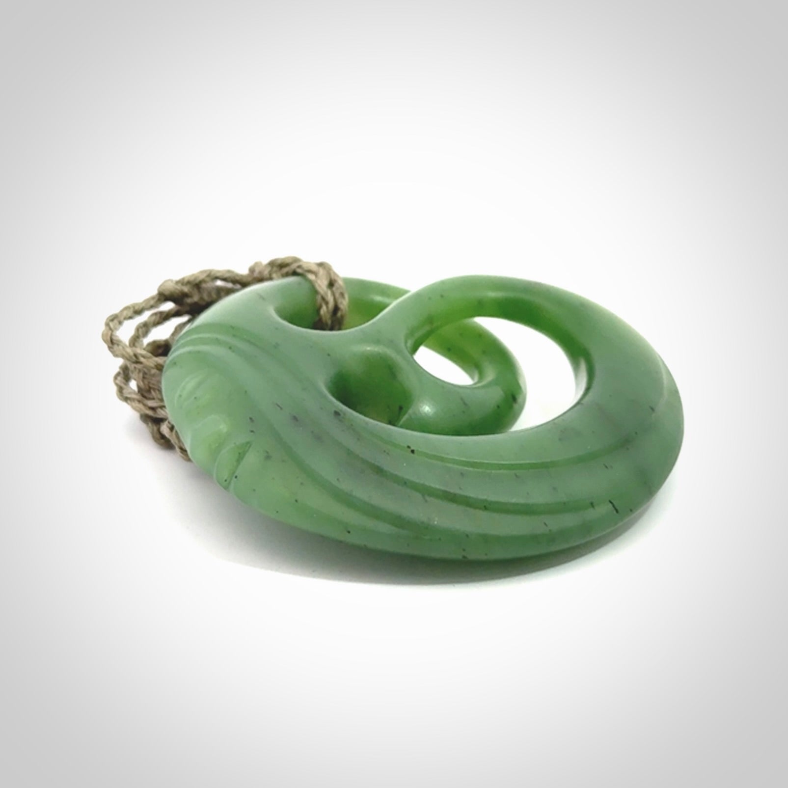 A hand carved complex face pendant from Siberian Jade. The cord is 4-plait khaki and is adjustable.
