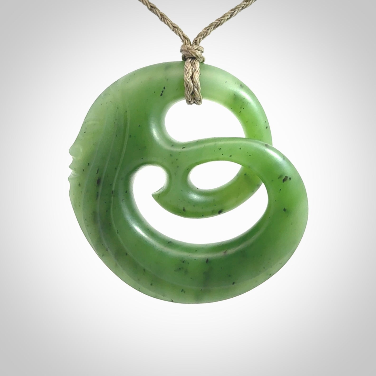 A hand carved complex face pendant from Siberian Jade. The cord is 4-plait khaki and is adjustable.