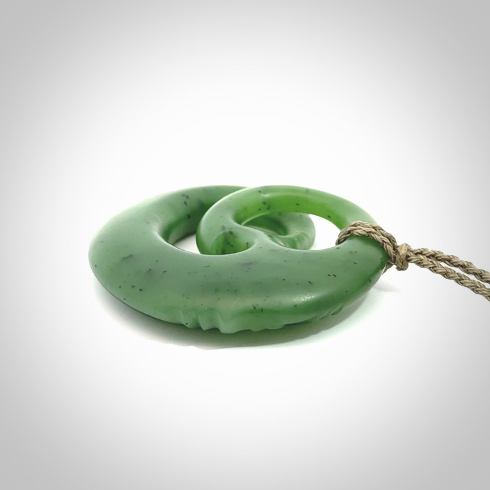 A hand carved complex face pendant from Siberian Jade. The cord is 4-plait khaki and is adjustable.