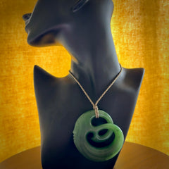 A hand carved complex face pendant from Siberian Jade. The cord is 4-plait khaki and is adjustable.