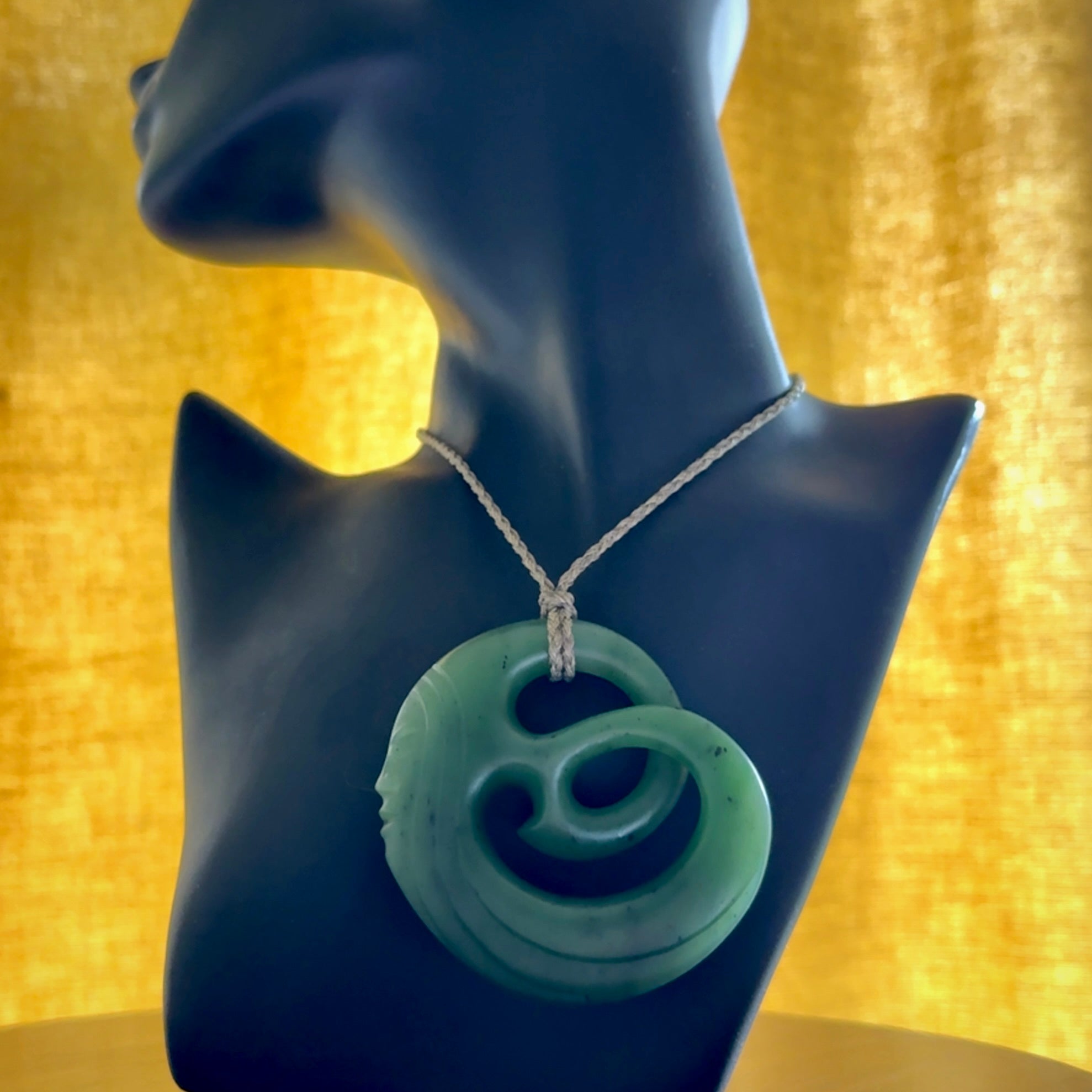 A hand carved complex face pendant from Siberian Jade. The cord is 4-plait khaki and is adjustable.