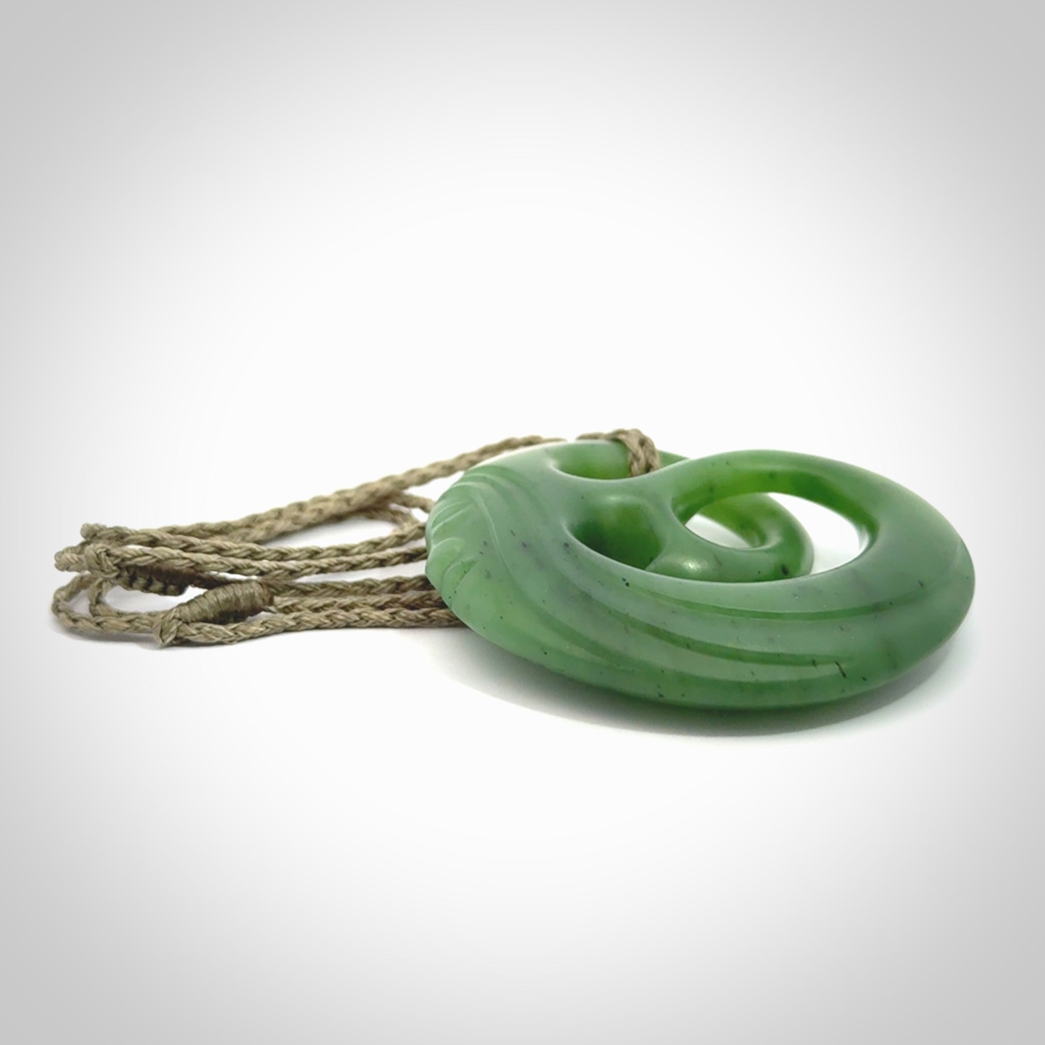 A hand carved complex face pendant from Siberian Jade. The cord is 4-plait khaki and is adjustable.