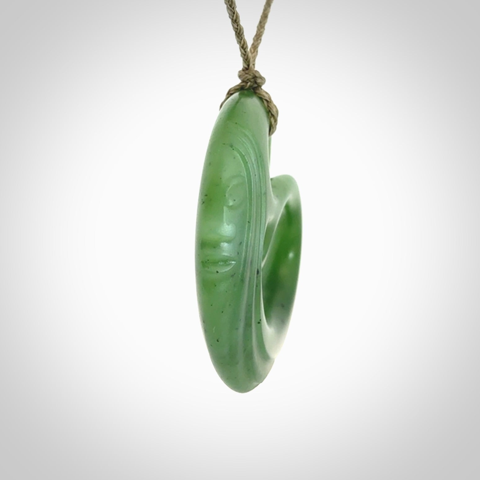 A hand carved complex face pendant from Siberian Jade. The cord is 4-plait khaki and is adjustable.