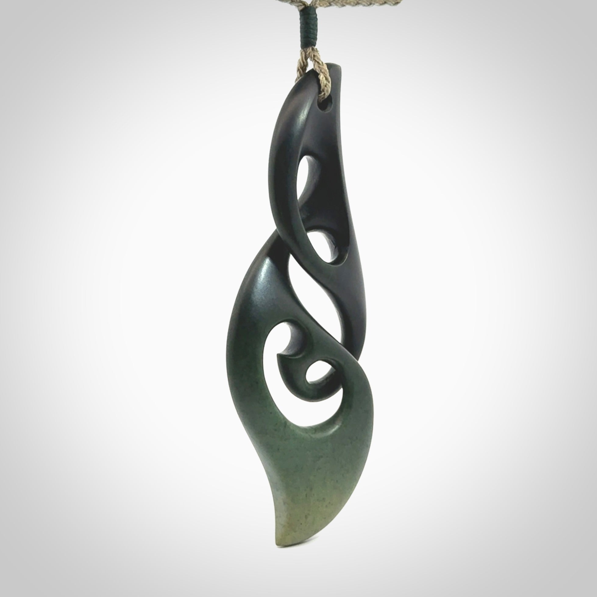 Hand carved New Zealand jade, complex twist drop pendant. Hand made complex twist pendant hand carved in New Zealand. Made by NZ Pacific, jade jewellery for sale online. One only hand made by Kerry Thompson.