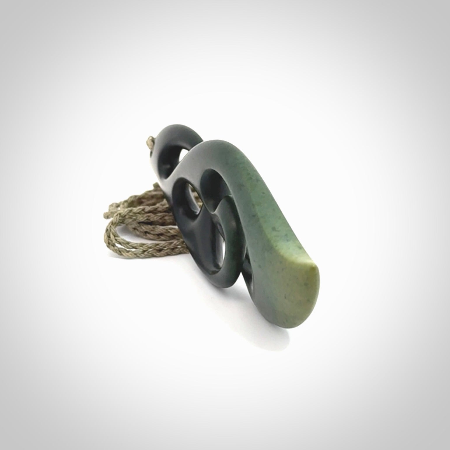 Hand carved New Zealand jade, complex twist drop pendant. Hand made complex twist pendant hand carved in New Zealand. Made by NZ Pacific, jade jewellery for sale online. One only hand made by Kerry Thompson.