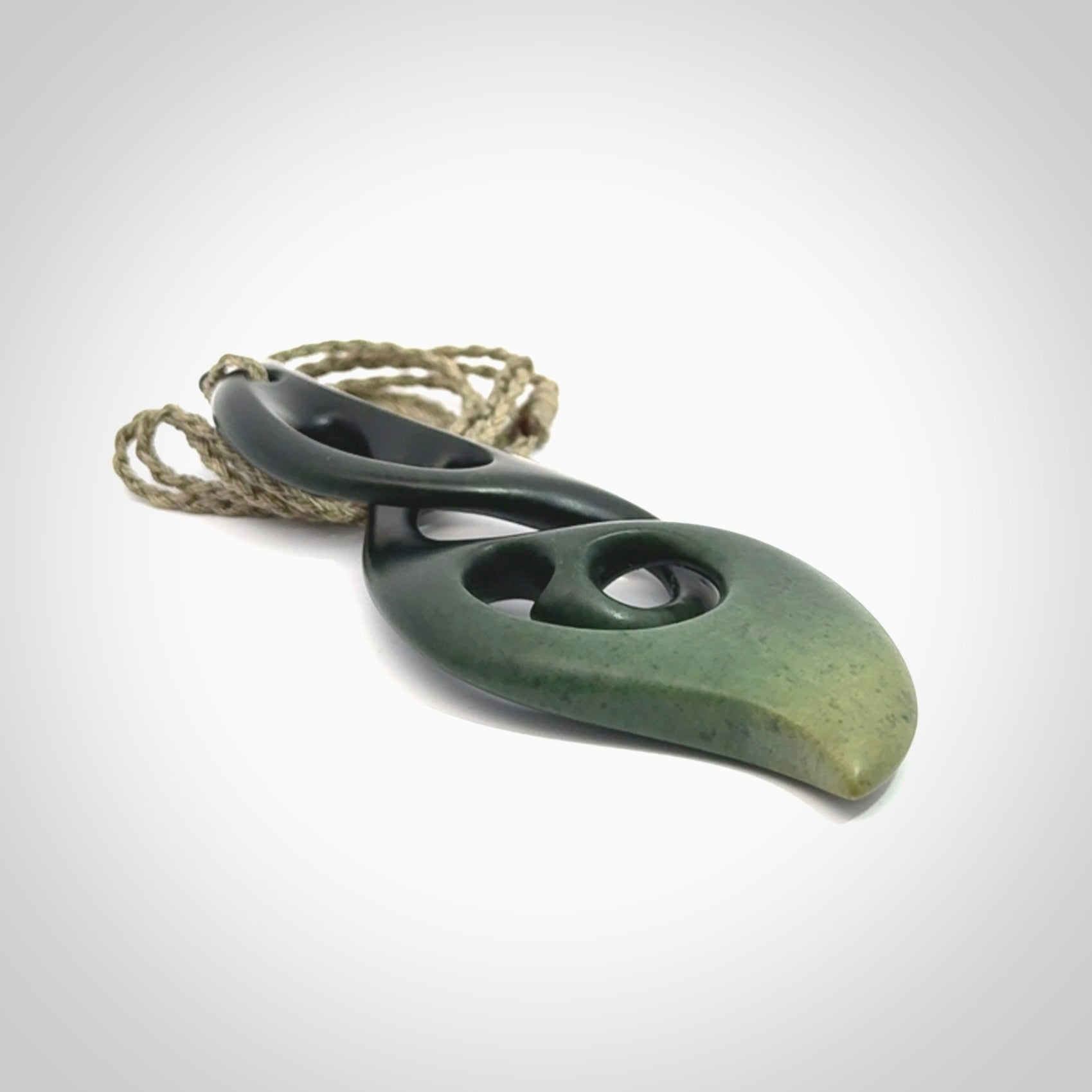 Hand carved New Zealand jade, complex twist drop pendant. Hand made complex twist pendant hand carved in New Zealand. Made by NZ Pacific, jade jewellery for sale online. One only hand made by Kerry Thompson.