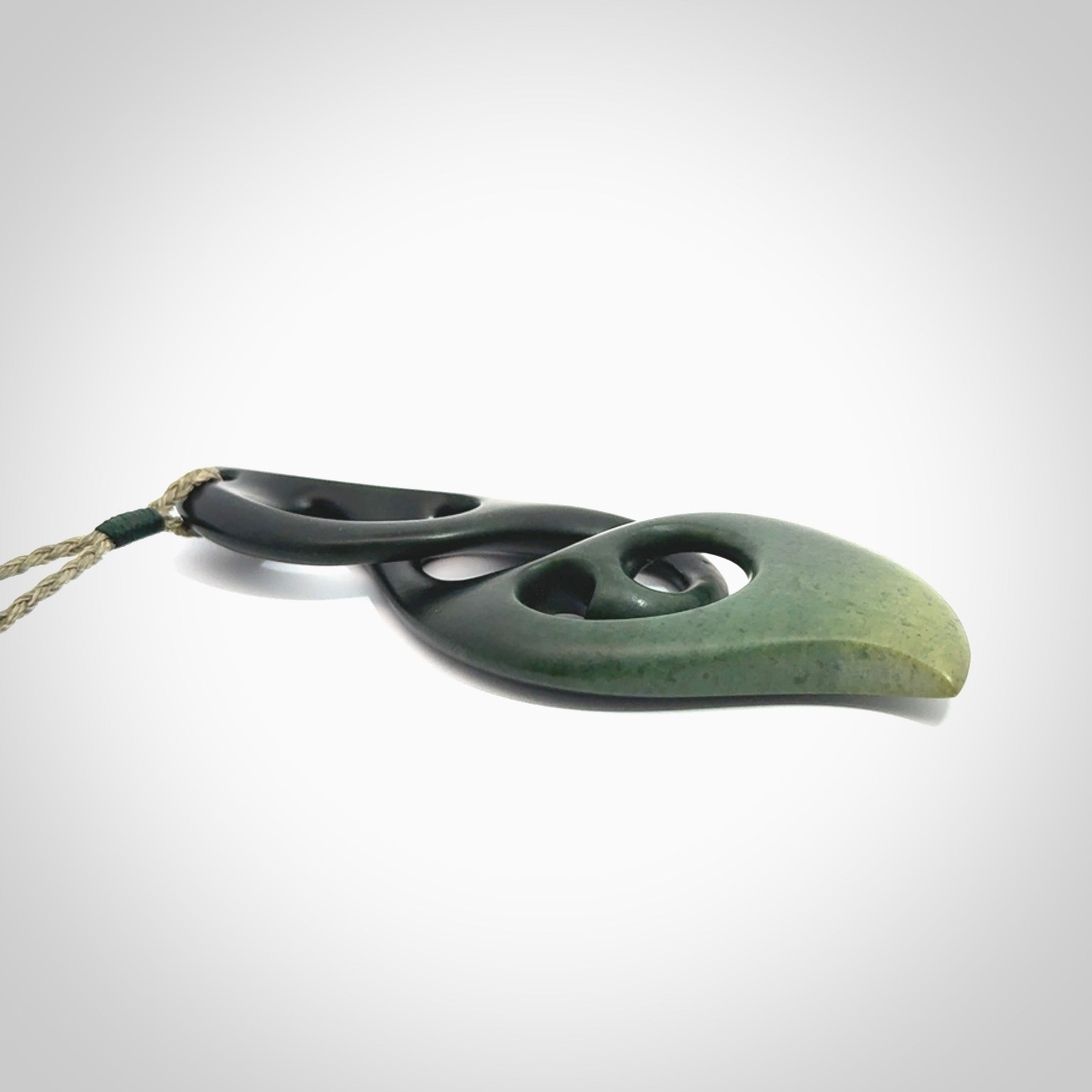 Hand carved New Zealand jade, complex twist drop pendant. Hand made complex twist pendant hand carved in New Zealand. Made by NZ Pacific, jade jewellery for sale online. One only hand made by Kerry Thompson.