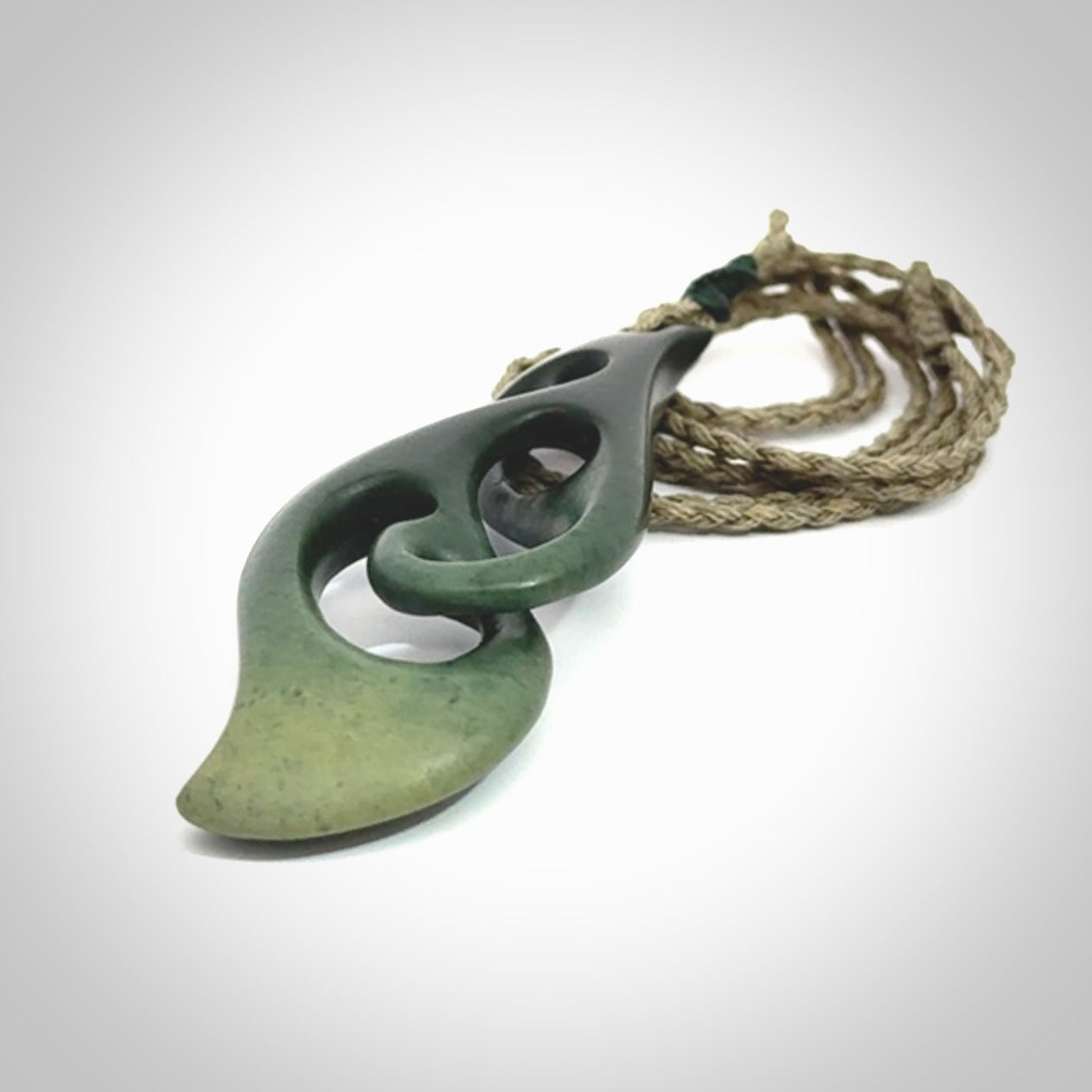 A hand carved twist pendant from New Zealand Jade. The cord is a khaki green colour and is adjustable.