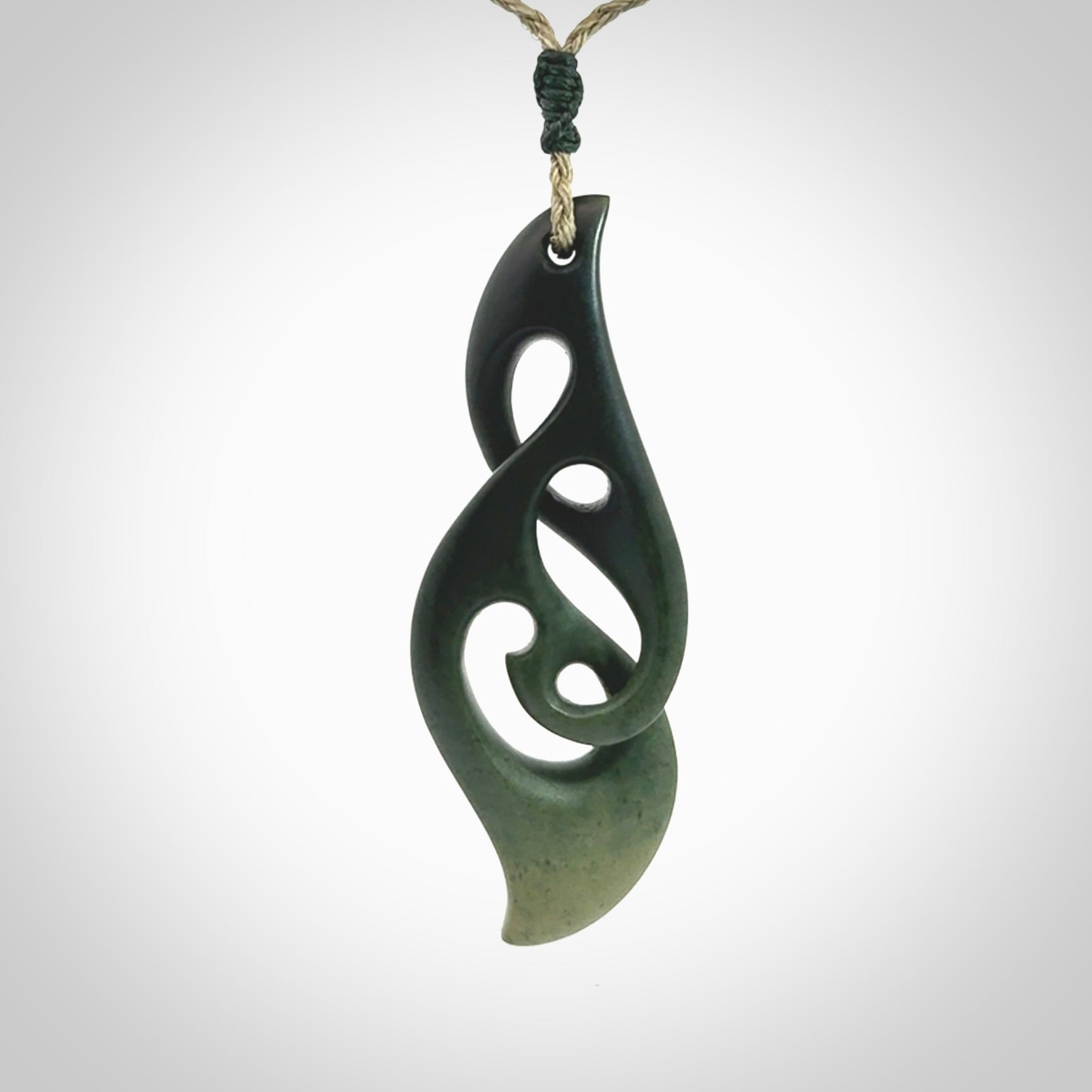 A hand carved twist pendant from New Zealand Jade. The cord is a khaki green colour and is adjustable.