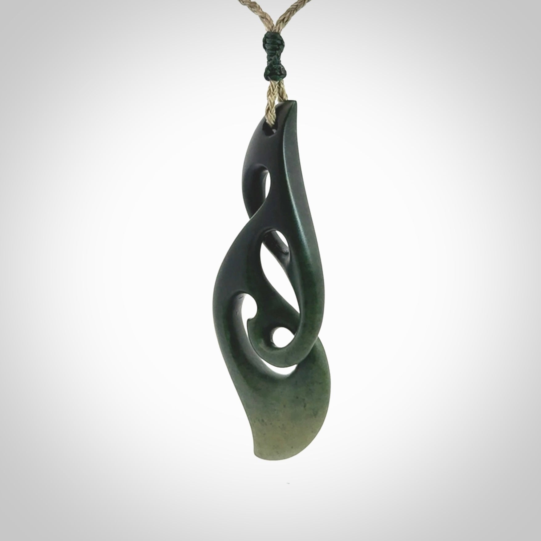 A hand carved twist pendant from New Zealand Jade. The cord is a khaki green colour and is adjustable.