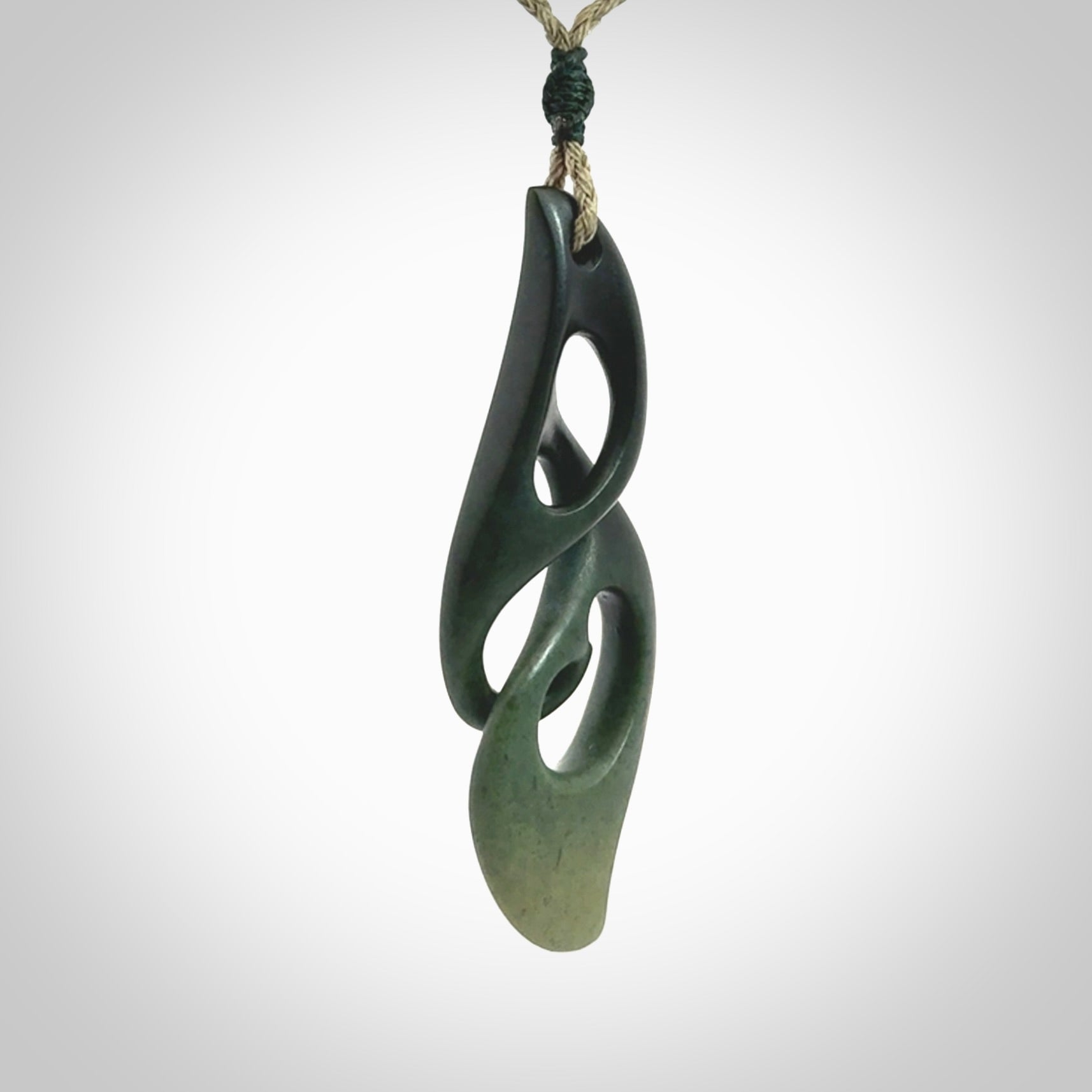 A hand carved twist pendant from New Zealand Jade. The cord is a khaki green colour and is adjustable.
