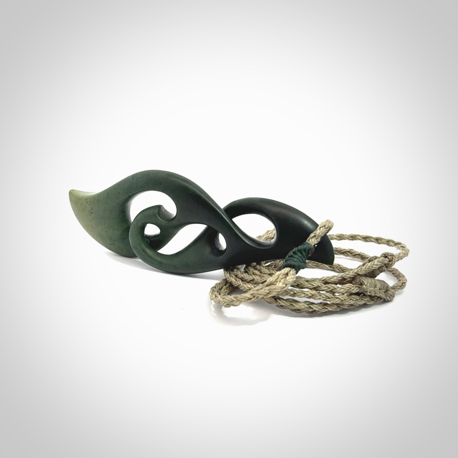 A hand carved twist pendant from New Zealand Jade. The cord is a khaki green colour and is adjustable.