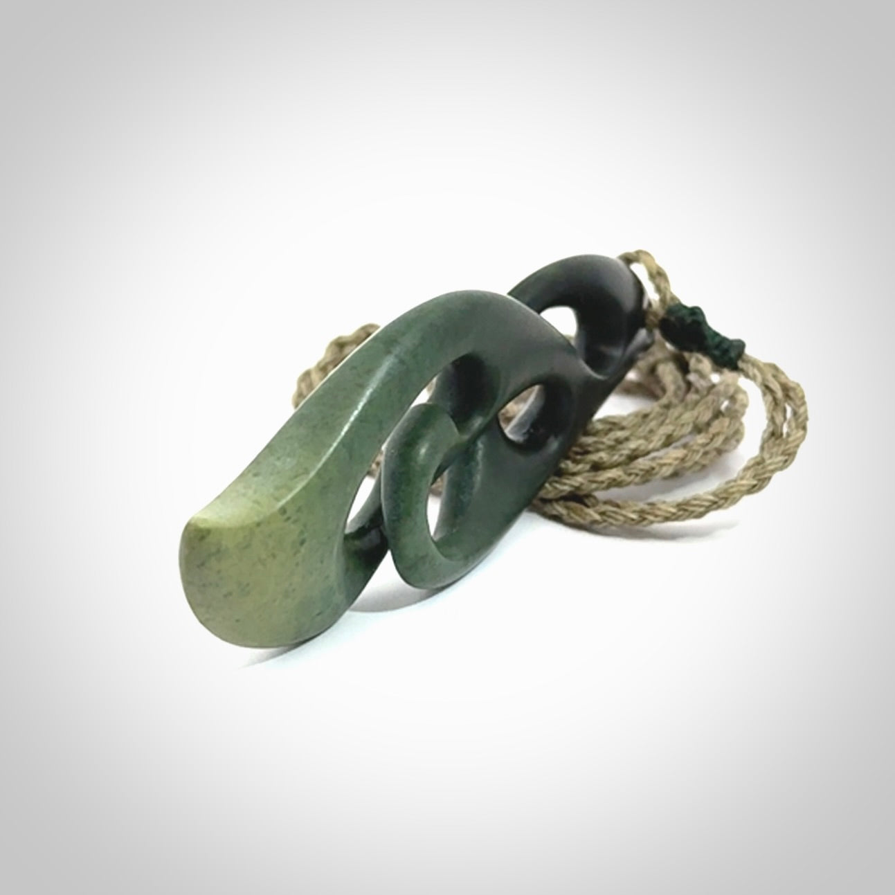 A hand carved twist pendant from New Zealand Jade. The cord is a khaki green colour and is adjustable.