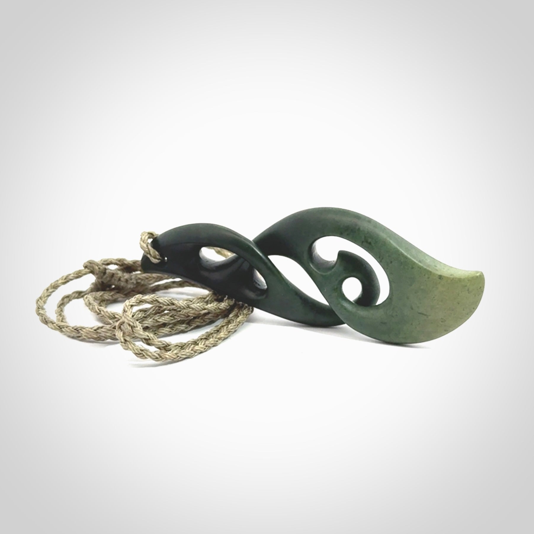 A hand carved twist pendant from New Zealand Jade. The cord is a khaki green colour and is adjustable.