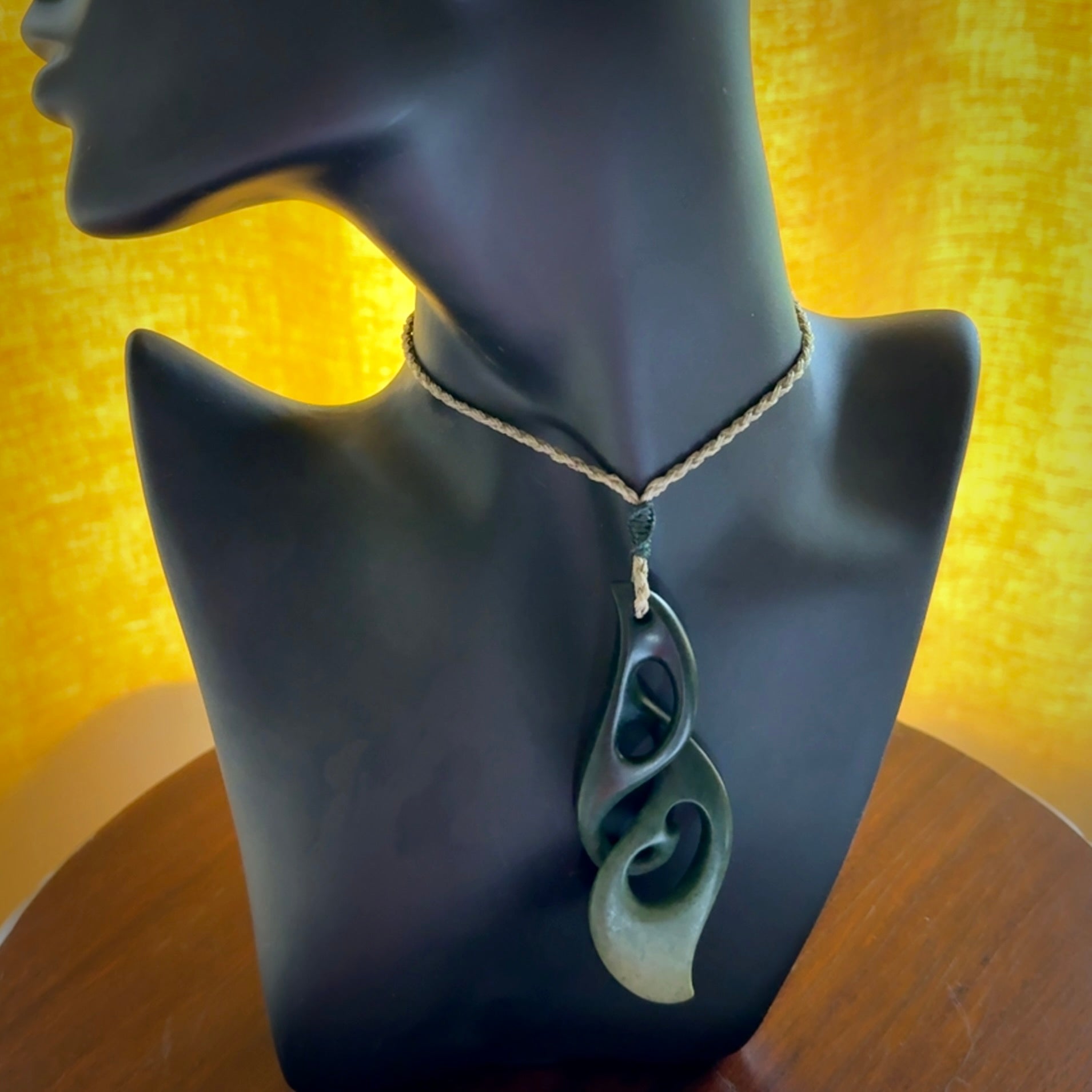 A hand carved twist pendant from New Zealand Jade. The cord is a khaki green colour and is adjustable.