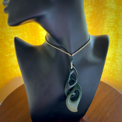 A hand carved twist pendant from New Zealand Jade. The cord is a khaki green colour and is adjustable.
