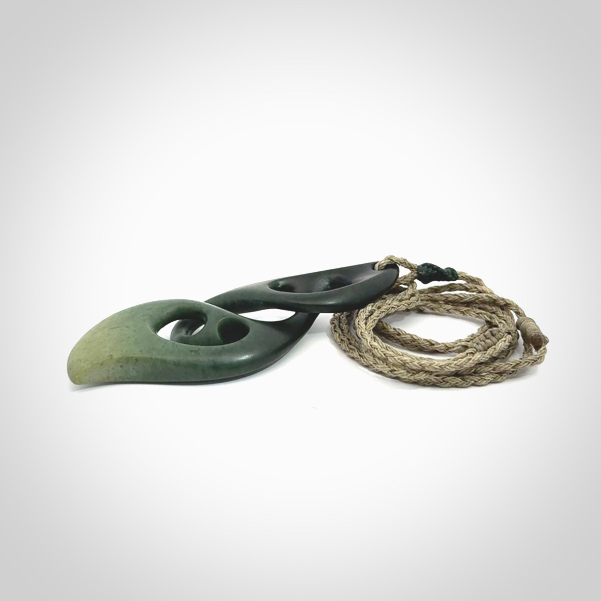 A hand carved twist pendant from New Zealand Jade. The cord is a khaki green colour and is adjustable.