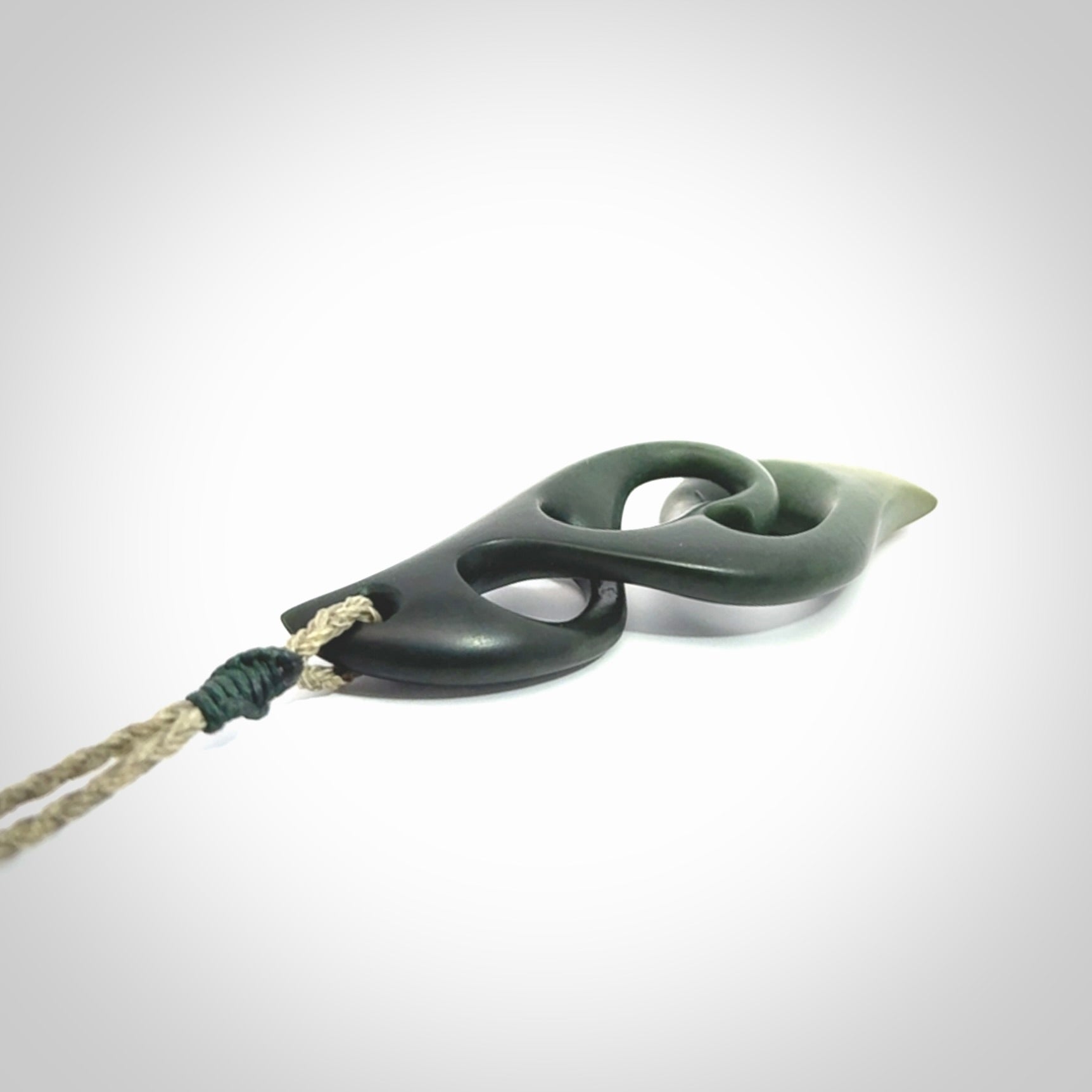 A hand carved twist pendant from New Zealand Jade. The cord is a khaki green colour and is adjustable.