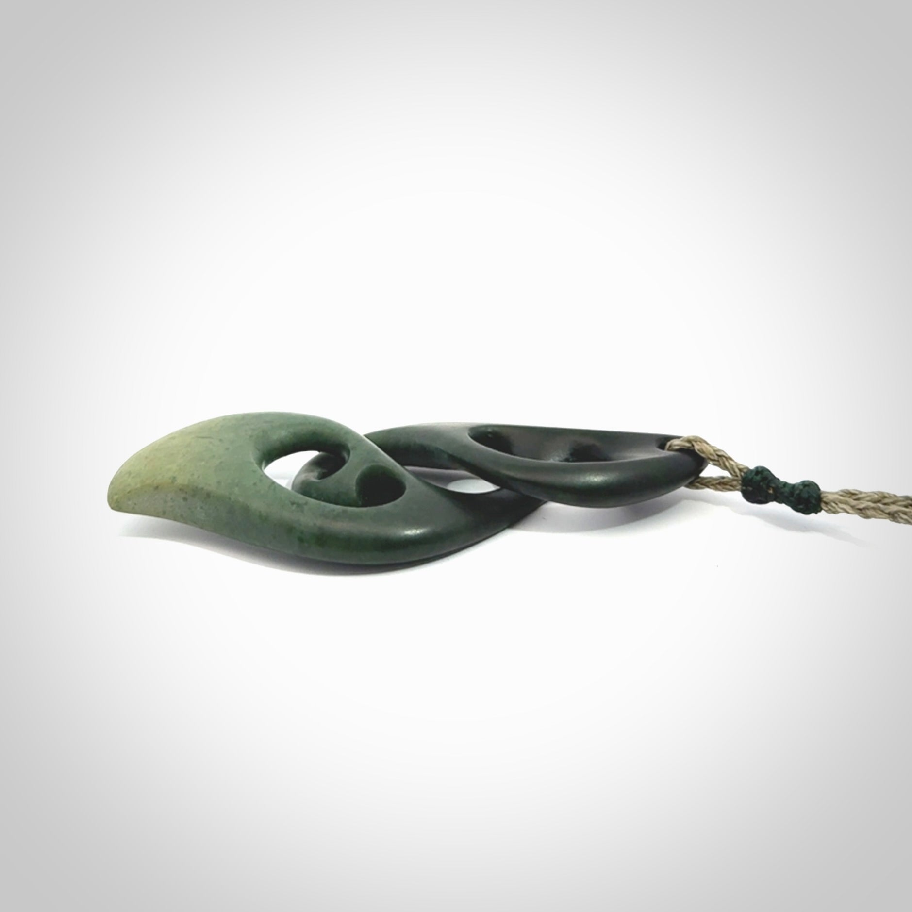 A hand carved twist pendant from New Zealand Jade. The cord is a khaki green colour and is adjustable.