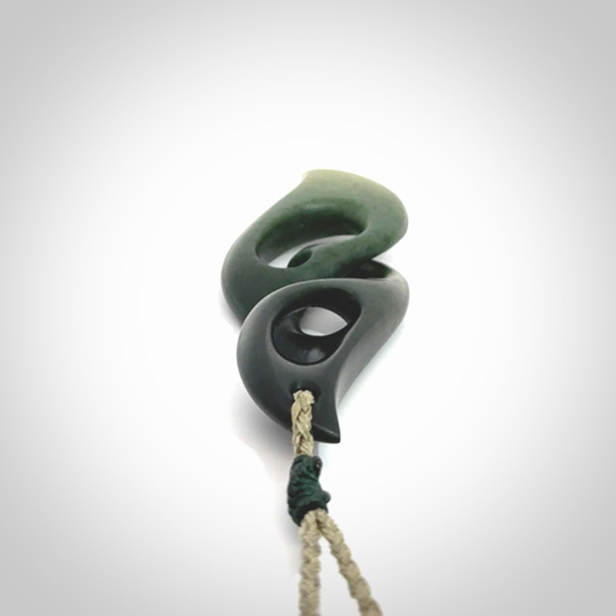 A hand carved twist pendant from New Zealand Jade. The cord is a khaki green colour and is adjustable.