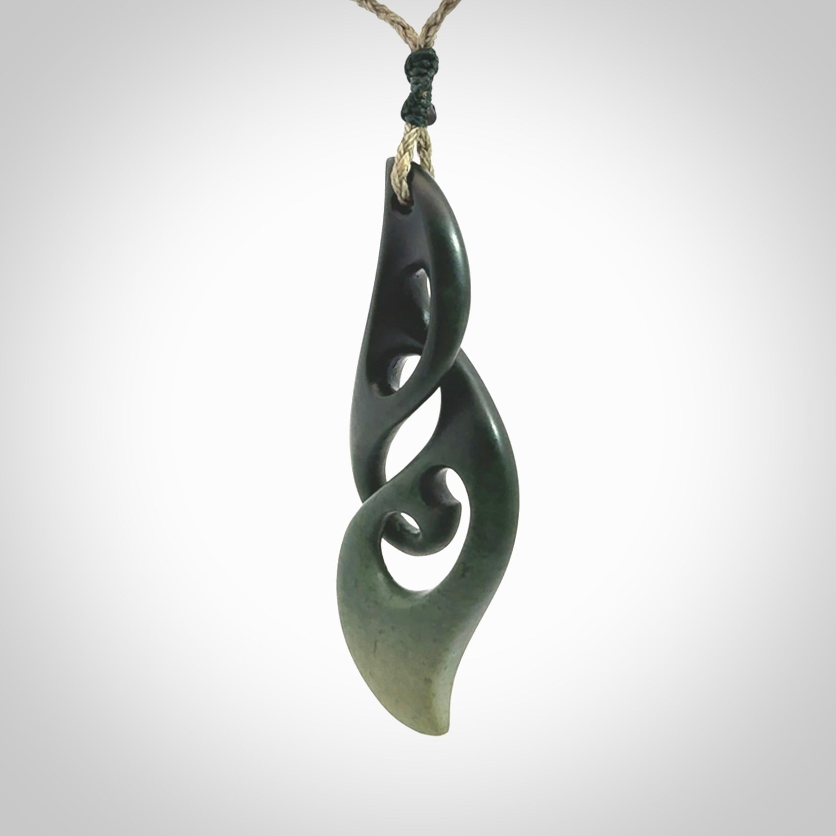 A hand carved twist pendant from New Zealand Jade. The cord is a khaki green colour and is adjustable.