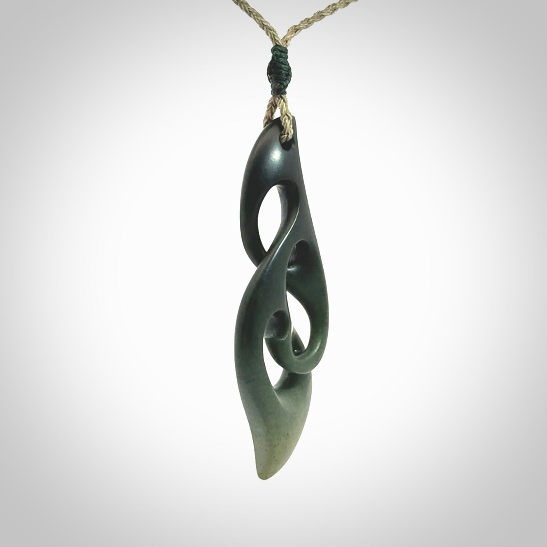 A hand carved twist pendant from New Zealand Jade. The cord is a khaki green colour and is adjustable.