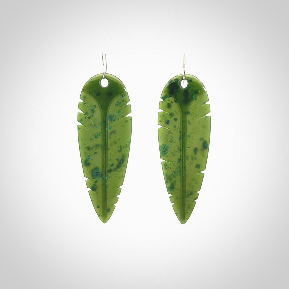 This picture shows British Columbian jade kaka feather earrings with sterling silver hooks. Hand made unique and contemporary feather earrings by Kerry Thompson. Hand carved here in New Zealand from British Columbian Jade. One pair only.