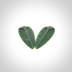 This picture shows British Columbian jade kaka feather earrings with sterling silver hooks. Hand made unique and contemporary feather earrings by Kerry Thompson. Hand carved here in New Zealand from British Columbian Jade. One pair only.