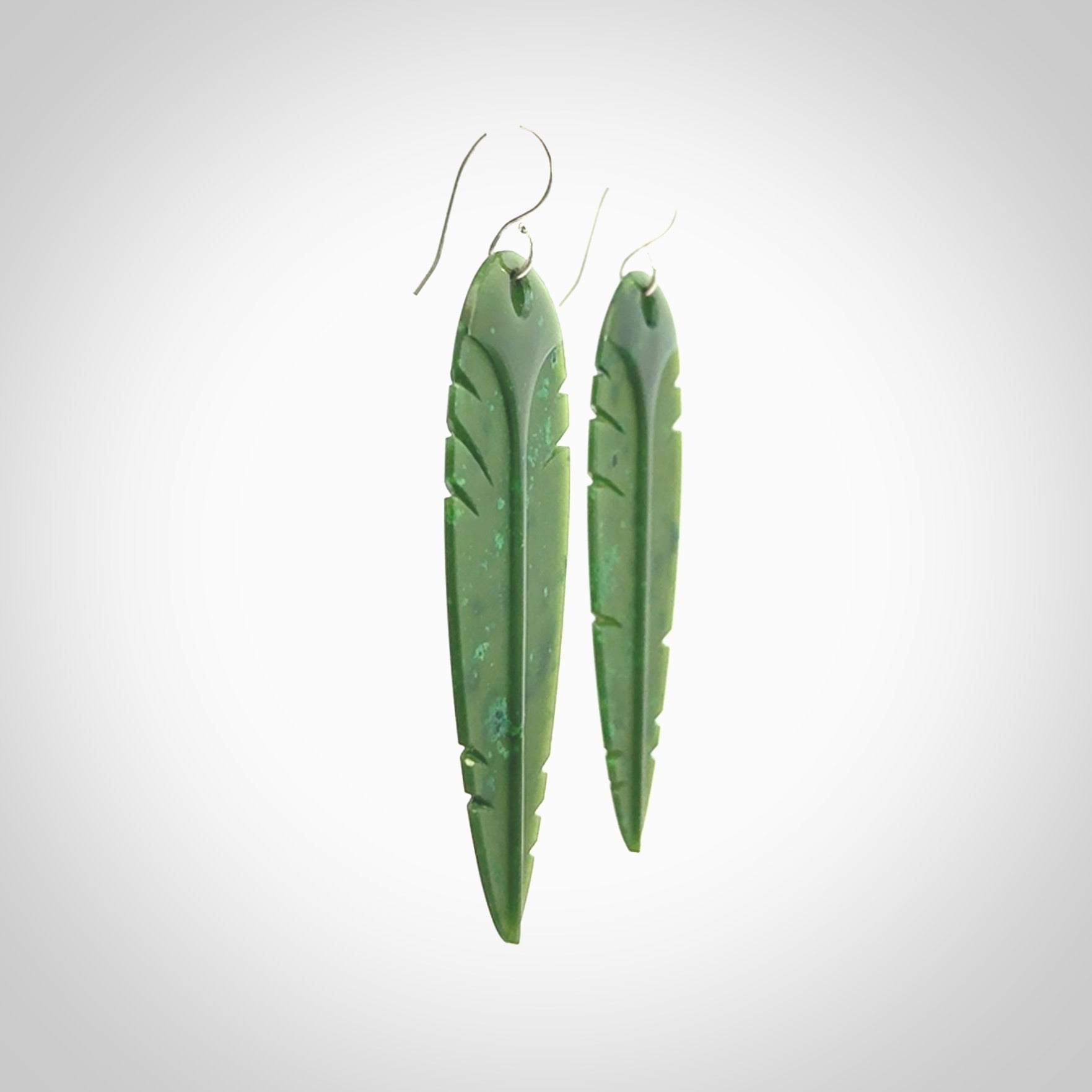 This picture shows British Columbian jade kaka feather earrings with sterling silver hooks. Hand made unique and contemporary feather earrings by Kerry Thompson. Hand carved here in New Zealand from British Columbian Jade. One pair only.